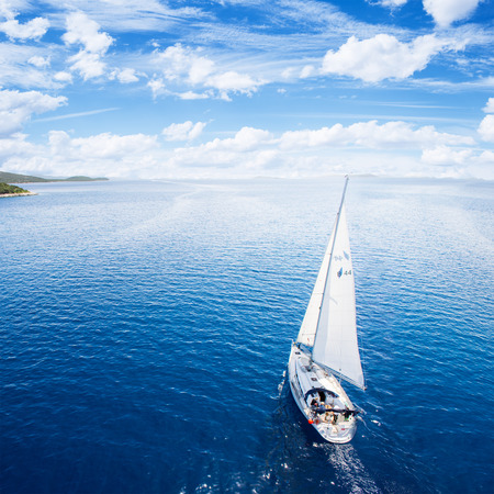 Yacht sailing on open sea at windy dayの写真素材