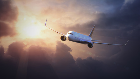 Airplane in the sky at sunsetの写真素材
