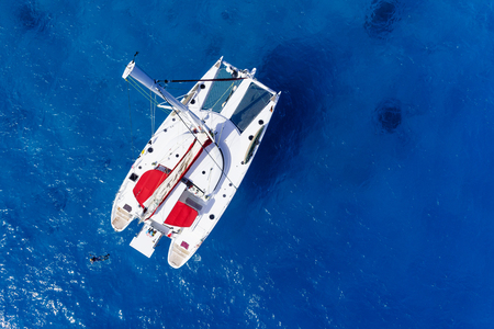 Amazing view to Catamaran cruising in open sea at windy day. Drone view - birds eye angle Coco Island.の写真素材