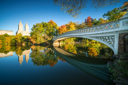 Famous Bow Bridge in New York City Central park with beautiful sunrise light over trees in fall.の写真素材