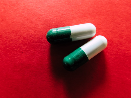 Pills medicine on red backgroundの写真素材