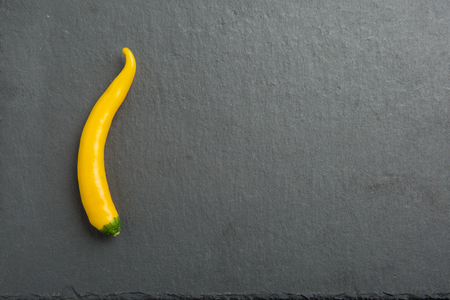 green and yellow chili pepper on dark backgroundの写真素材