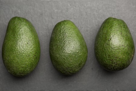 three avocado top view on a dark background top viewの写真素材