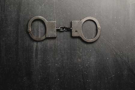 Metal handcuffs with dark background,