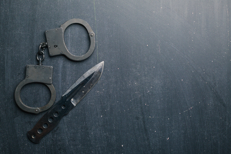 Tactical gear set of knife and handcuff on dark background. Police or military equipment concept.の写真素材