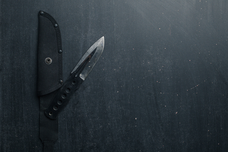 Black tactical knife on black background. Military. Top view. Copy space.の写真素材