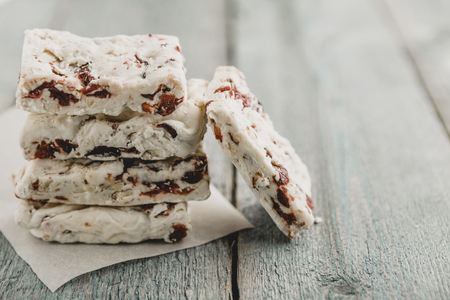 Hard nougat on wooden background, cut into piecesの写真素材