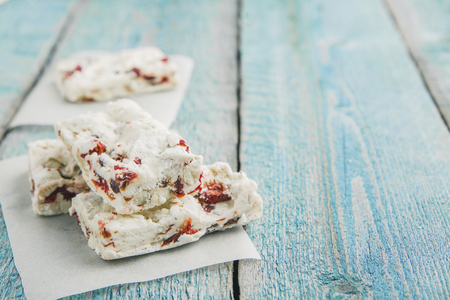 Hard nougat on wooden background, cut into piecesの写真素材