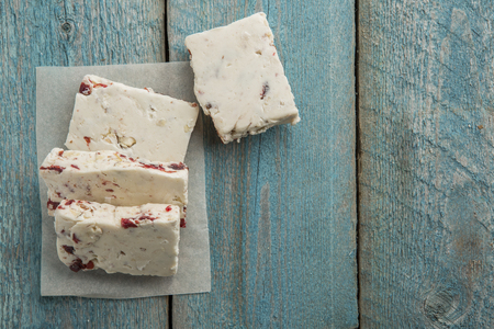 White nougat on wooden background, cut into pieces top viewの写真素材