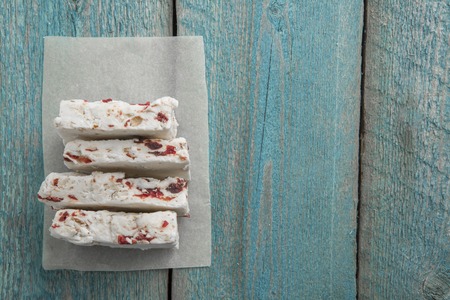 white nougat on wooden background, cut into pieces top viewの写真素材