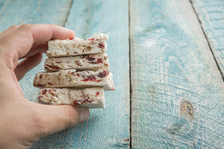 Hand Holding The Traditional Pieces Of White Nougat Dessert Sweet Candiesの写真素材