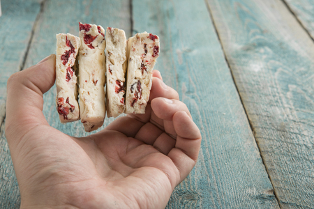 Hand Holding The Traditional Pieces Of White Nougat Dessert Sweet Candiesの写真素材