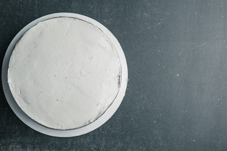Tasty white homemade cake on dark bacground top viewの写真素材