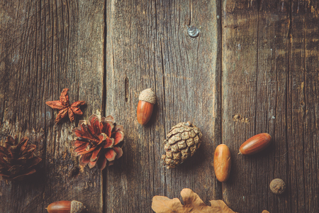 Autumn composition. Frame made of autumn dried leaves, acorns, pine cones on dark wooden vintage background. Autumn, fall, background. Flat lay, top view, copy spaceの写真素材