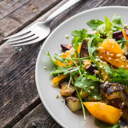 Warm salad with fried eggplant, arugula, orange tomatoes, , sesame seeds ,delicious healthy dinner, summer dish, diet foodの写真素材