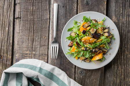 Warm salad with fried eggplant, arugula, orange tomatoes, , sesame seeds ,delicious healthy dinner, summer dish, diet foodの写真素材