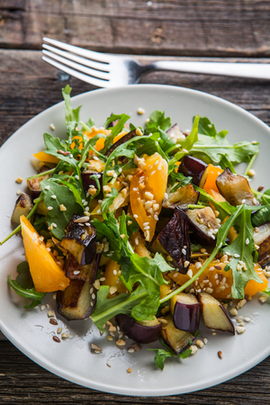 Warm salad with fried eggplant, arugula, orange tomatoes, , sesame seeds ,delicious healthy dinner, summer dish, diet foodの写真素材