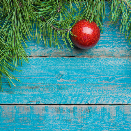 Christmas decoration red ball with green fir branch on old blue wooden backgroundの写真素材