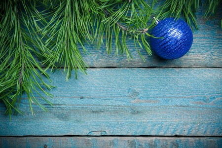 Christmas decoration blue ball with green fir branch on old blue wooden backgroundの写真素材