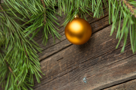 Yellow christmas tree bauble on old wooden table.の写真素材