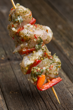 Raw chicken skewers with tomatoes and vegetables.の写真素材