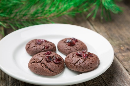 Homemade christmas and new year chocolate cookies with cranberry on wooden table background.の写真素材