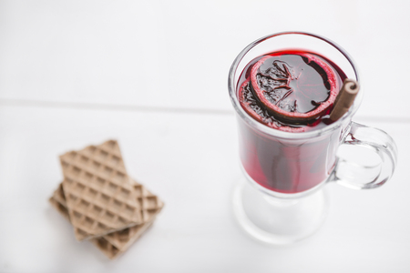 Christmas drink and waffles on white wooden background. Traditional mulled wine with spices. Christmas, winter, new year concept.の写真素材