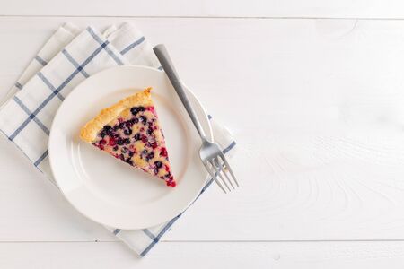 Pie with red currant and blueberries on a white wooden background. Copy space. Top view.の写真素材