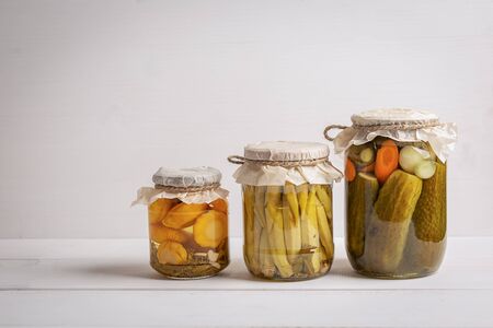 Marinated preserved squash, cucumbers and okra in jar on white backgrouの写真素材