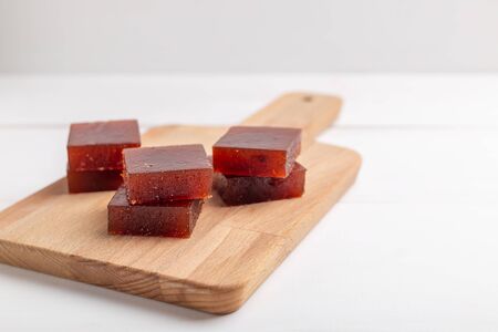 Red cubes of marmalade made from berries on white background selective focusの写真素材