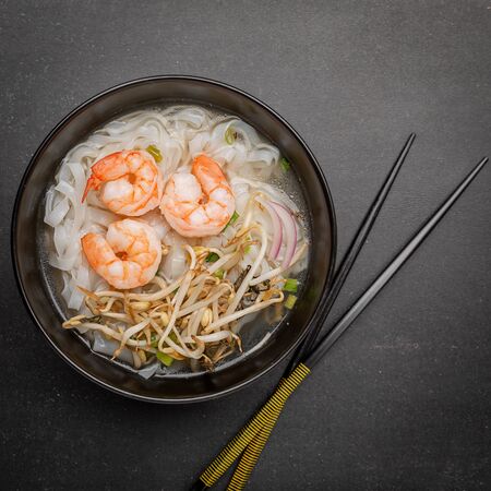 Vietnamese Pho tom noodle broth asian soup prawn. Top view with copy space on dark or black...