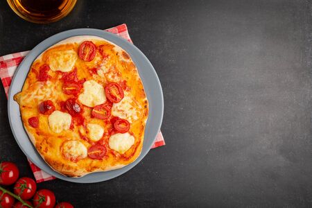 Homemade Pizza Margarita with Tomatoes, Basil and Mozzarella Cheese on gray plate ,top viewの写真素材
