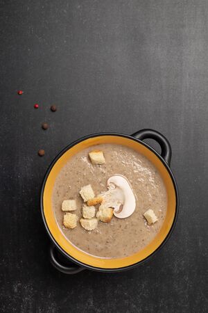 Delicious mushroom champignon cream soup on dark background. Top view with copy spaceの写真素材
