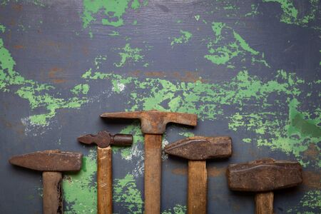 Set of old hammers and rusty nails. tools on old metal the surface. Top view with copy space tonned imageの写真素材
