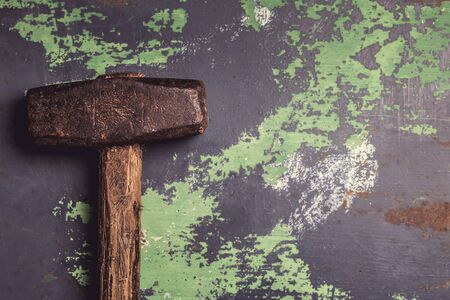 Old and scratched hammer on metal surface. Top view with copy space, toned imageの写真素材
