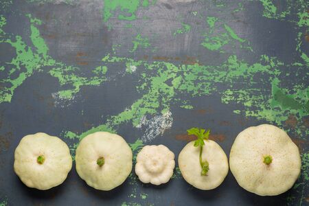Fresh white squash vegetables on old iron colored background. Top view with copy spaceの写真素材