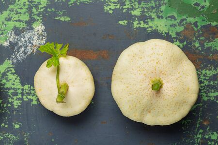 Two Fresh white squash vegetables on old iron colored background. Top view with copy spaceの写真素材