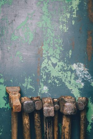 Set of old hammers and rusty nails. tools on old metal the surface. Top view with copy space tonned imageの写真素材