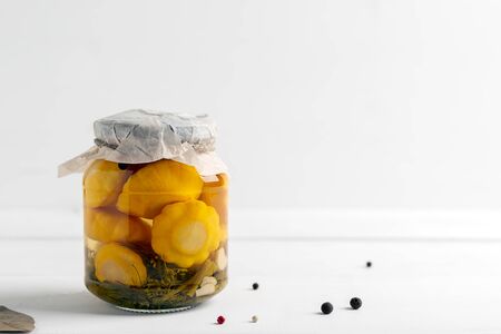 Glass jar with canned squash and spice on white wooden backgroundの写真素材