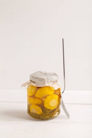 Glass jar with canned squash with fork on white wooden backgroundの写真素材