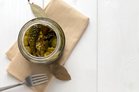 Pickled cucumbers closeup in a jar. Top view with copy space. Homemade preserveed vegetable.の写真素材