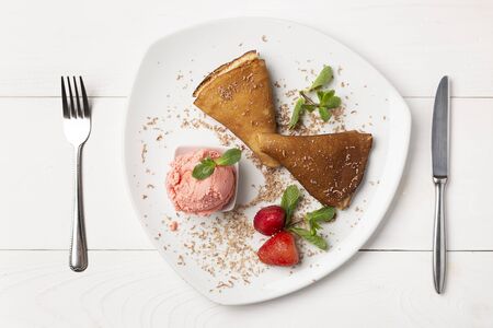 Delicious pancakes on white wooden table with strawberries and ice cream top viewの写真素材