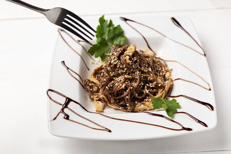 Delicious soba noodles on a square white plateの写真素材