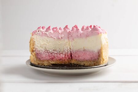 Delicious homemade cheesecake with berries on white wooden surface.の写真素材