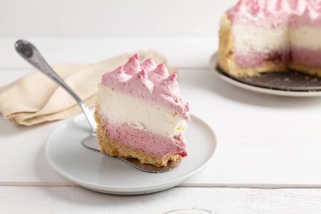 Piece of Delicious homemade cheesecake with berries on white wooden surface.の写真素材