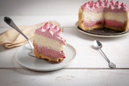 Piece of Delicious homemade cheesecake with berries on white wooden surface.の写真素材