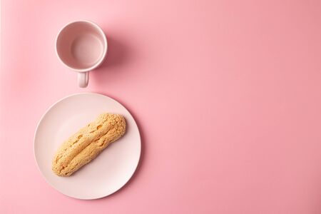 Eclair on the plate. Pink pastel background. Dessert. concept, minimalismの写真素材
