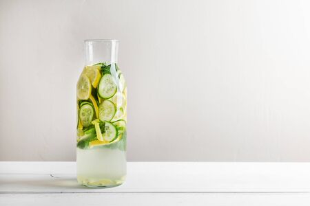Sassy diet water. Cucumber, lemon, mint lemonade in glasses on white wooden table.の写真素材