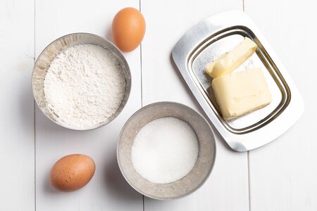 Baking ingredients on white table. Brown eggs, , flour, sugar . Home baking concept, baking cake or cookies ingredientsの写真素材