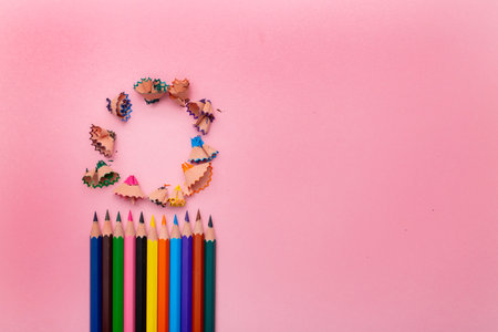 Many different colored pencils and shavings on pastel pink backgroundの写真素材